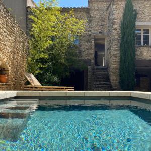 a swimming pool in front of a stone building at Haven of peace in luberon in Cabrières-dʼAvignon