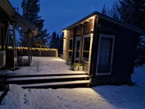 Una casa con le luci di Natale sulla neve di Villa Laiskajaakko a Vimpeli