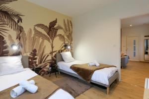 una camera da letto con due letti e un murale di La chute des feuilles - 2 Lits simples - T2 Hyper centre a Abbeville