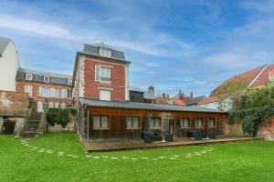 un grande edificio in mattoni con un ponte in un cortile di La chute des feuilles - 2 Lits simples - T2 Hyper centre a Abbeville