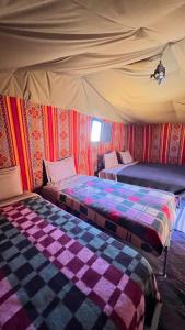 a bedroom with two beds in a tent at luna camp merzouga in Merzouga