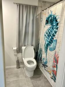 a bathroom with a seahorse shower curtain and a toilet at The Cottage - A Private Oceanfront Dream! in East Sooke +74 photos