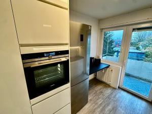 Il comprend une cuisine équipée d'une cuisinière et d'un réfrigérateur. dans l'établissement Moderne 3-Zi, King-Size Betten, Küche, Badewanne, à Karlsruhe