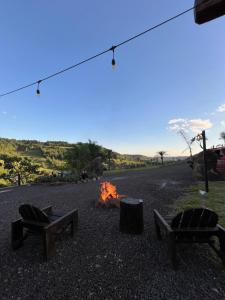 a campfire with two chairs and a fire pit at Refúgio Da Lua - Buss motorhome in Ametista do Sul