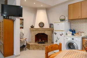 a kitchen with a fireplace with a stove and a refrigerator at Anastasia's House in Plátanos