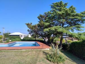 a swimming pool in a yard with a tree at Casa con pileta cómoda y equipada in Villa Carlos Paz +3 photos