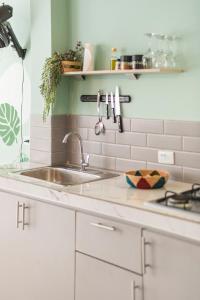 Una cocina blanca con fregadero y estufa. en Casa Oasis, en Villavicencio