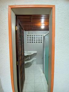 a bathroom with a walk in shower and a sink at Casa de Praia Aconchegante in Peruíbe