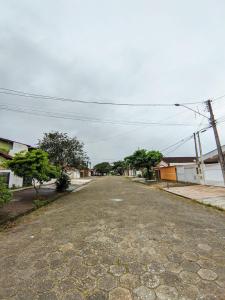 an empty street in a small town with trees at Casa de Praia Aconchegante in Peruíbe