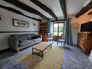 a living room with a couch and a table at Châteauneuf-du-Faou, Finistre, Brittany in Châteauneuf-du-Faou
