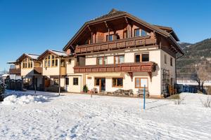 a large house in the snow in front at Apartmenthaus Pernull in Tröpolach