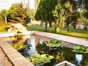 a pool of water with lilies in a garden at Motel Maritsa in Dimitrovgrad