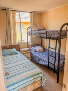 拉塞雷纳Departamento a 5 minutos de la playa的一间卧室，有两张双层床和一扇窗户