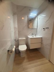 ein weißes Badezimmer mit Toilette und Waschbecken in der Unterkunft Morosini Apartments in Biograd na Moru