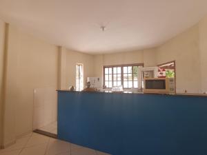 a large kitchen with a blue counter top at Suíte Pousada Rio das Ostras VII in Rio das Ostras