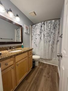 Un baño con lavabo, inodoro y cortina de ducha. en 3 Bedroom Townhouse-Max 8 guests, en Charlotte