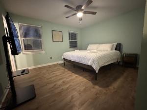 Un dormitorio con una cama y un ventilador de techo. en 3 Bedroom Townhouse-Max 8 guests, en Charlotte