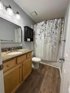 Un baño con inodoro y cortina de ducha. en 3 Bedroom Townhouse-Max 8 guests, en Charlotte