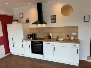 a kitchen with white cabinets and a sink at Ommi Kese See-Suite Sauna Biggesee in Olpe