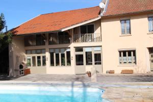 a house with a swimming pool in front of it at Sous Le Figuier in Saint-Siméon-de-Bressieux