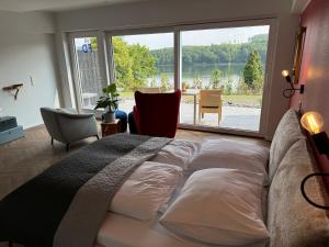 a bedroom with a large bed and a large window at Ommi Kese See-Suite Sauna Biggesee in Olpe