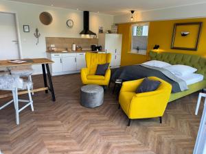 a bedroom with a bed and two chairs and a table at Ommi Kese See-Suite Sauna Biggesee in Olpe +16 photos