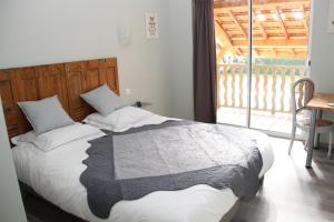 ein Schlafzimmer mit einem Bett und einem Balkon in der Unterkunft Sous Le Figuier in Saint-Siméon-de-Bressieux