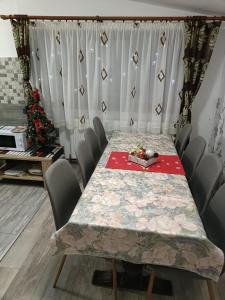 a dining room with a table and a christmas tree at Casa Alex in Topliţa