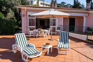 a patio with two chairs and a table and an umbrella at Casa Magazzini in Magazzini