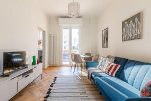 a living room with a blue couch and a tv at Oasis Apartment in Bologna