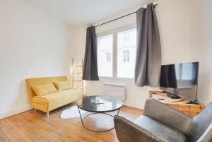 a living room with a couch and a television at Appartement place Stanislas 1er in Nancy