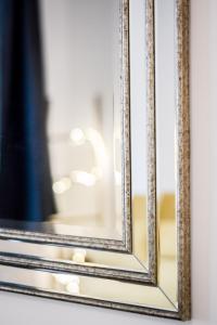 a mirror with a gold frame on a wall at Appartement place Stanislas 1er in Nancy +4 photos