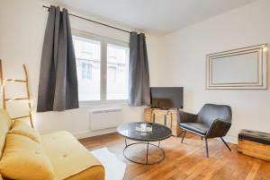 a living room with a couch and a table at Appartement place Stanislas 1er in Nancy