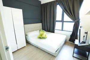 Un osito de peluche sentado en una cama en un dormitorio. en Luxury Apartments, en Genting Highlands