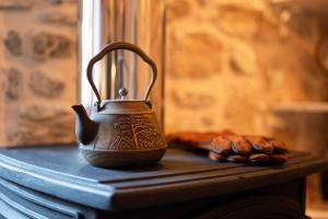 a kettle sitting on a table next to a pile of cookies at Physis Country House Near Matala Beach & Faistos in Kousés