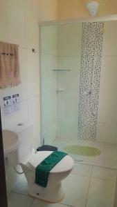 a bathroom with a shower and a toilet with a green towel at Recanto Dos Vargas in Florianópolis +38 photos