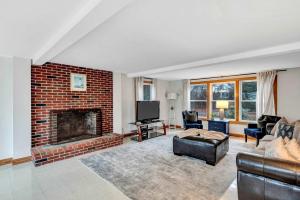 a living room with a brick fireplace and a couch at 5-Bedroom Cape Cod Retreat on Scraggy Neck in Cataumet