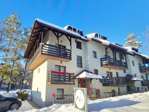 a large white building with snow on the ground at Apartman Sofy - Vila Panorama, SELF CHECK IN in Zlatibor