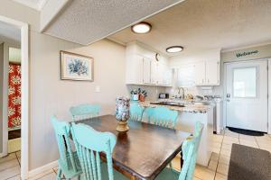 a kitchen and dining room with a wooden table and chairs at HB289 Feel the Burn in Holden Beach +13 photos