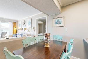 a dining room table with chairs and a vase on it at HB289 Feel the Burn in Holden Beach