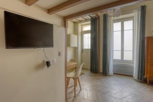 ein Wohnzimmer mit einem Flachbildfernseher an der Wand in der Unterkunft Le Saint Julien in Versailles