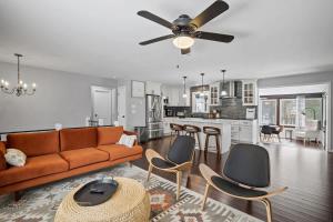a living room with a couch and chairs and a kitchen at Serene Lakeside Retreat with Hot Tub Near Gunstock in Gilford