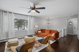 a living room with a couch and a ceiling fan at Serene Lakeside Retreat with Hot Tub Near Gunstock in Gilford