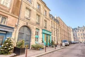 eine Reihe von Gebäuden in einer Stadtstraße mit Weihnachtsbäumen in der Unterkunft Le Saint Julien in Versailles