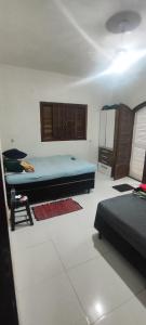 a bedroom with two beds and a refrigerator at Casa praia in Peruíbe