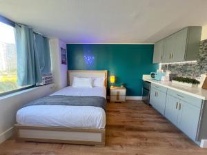 a bedroom with a bed and a blue wall at Magnificent Mana Studio at Hawaiian Monarch in Honolulu