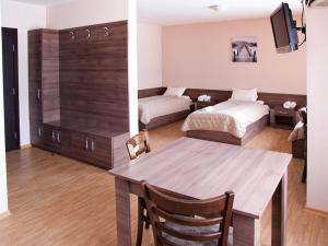 a living room with a dining table and a bedroom at Motel Maritsa in Dimitrovgrad