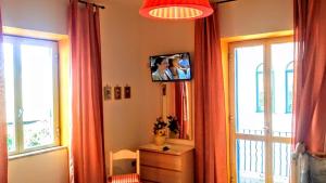 um quarto com um espelho e uma televisão na parede em Casa Filomena em Ischia