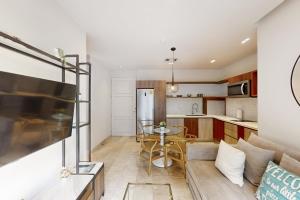 een keuken en woonkamer met een bank en een tafel bij Golden Wave Escape in Playa del Carmen
