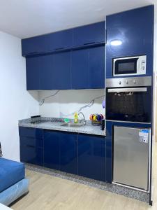 a blue kitchen with blue cabinets and a microwave at Escapade à Fes in Fès